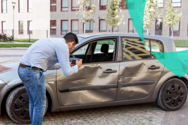 Mann fotografiert ein beschädigtes Auto für die Kfz-Versicherungsbewertung
