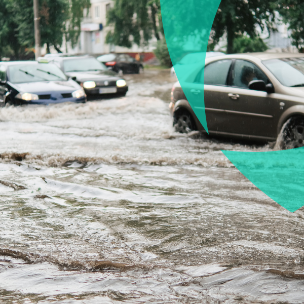Cars driving through a flooded street, illustrating overflow claims support during extreme weather events.