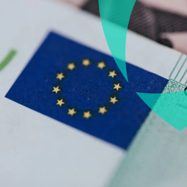 Close-up da bandeira da União Europeia em documentos oficiais, simbolizando a conformidade transfronteiriça em matéria de seguros.