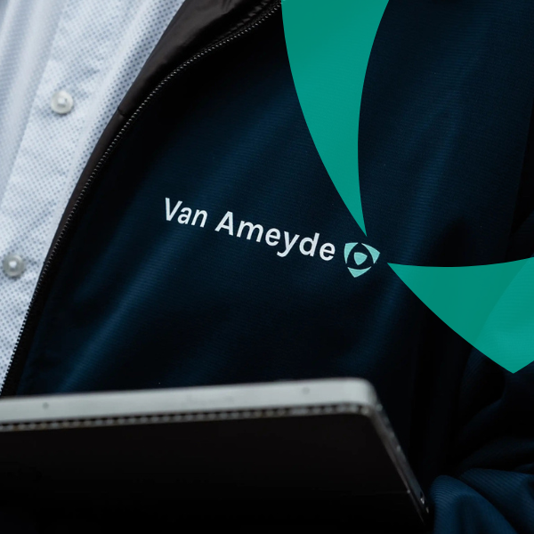 En specialist från Van Ameyde i professionell affärsklädsel som arbetar på en bärbar dator och representerar expertis inom skade- och skadeärendehantering.