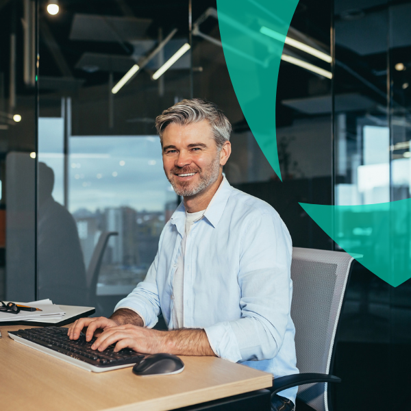 Smiling man working in an office representing interim professionals and claims management expertise by Van Ameyde